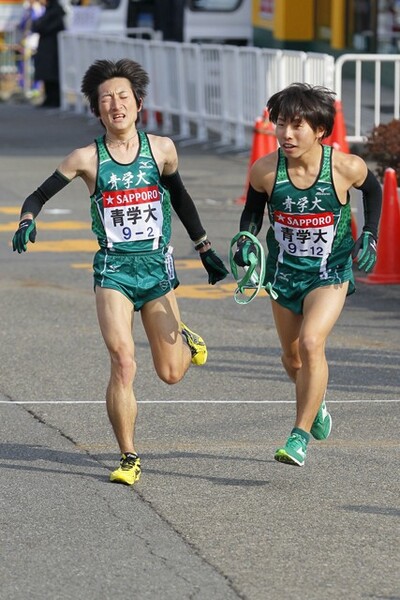 第88回大会で2区区間賞を獲得した出岐雄大(左)と、たすきを受け取った福田雄大