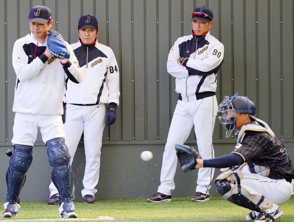 ブルペンで投球練習を見守る小久保監督(左から3人目)